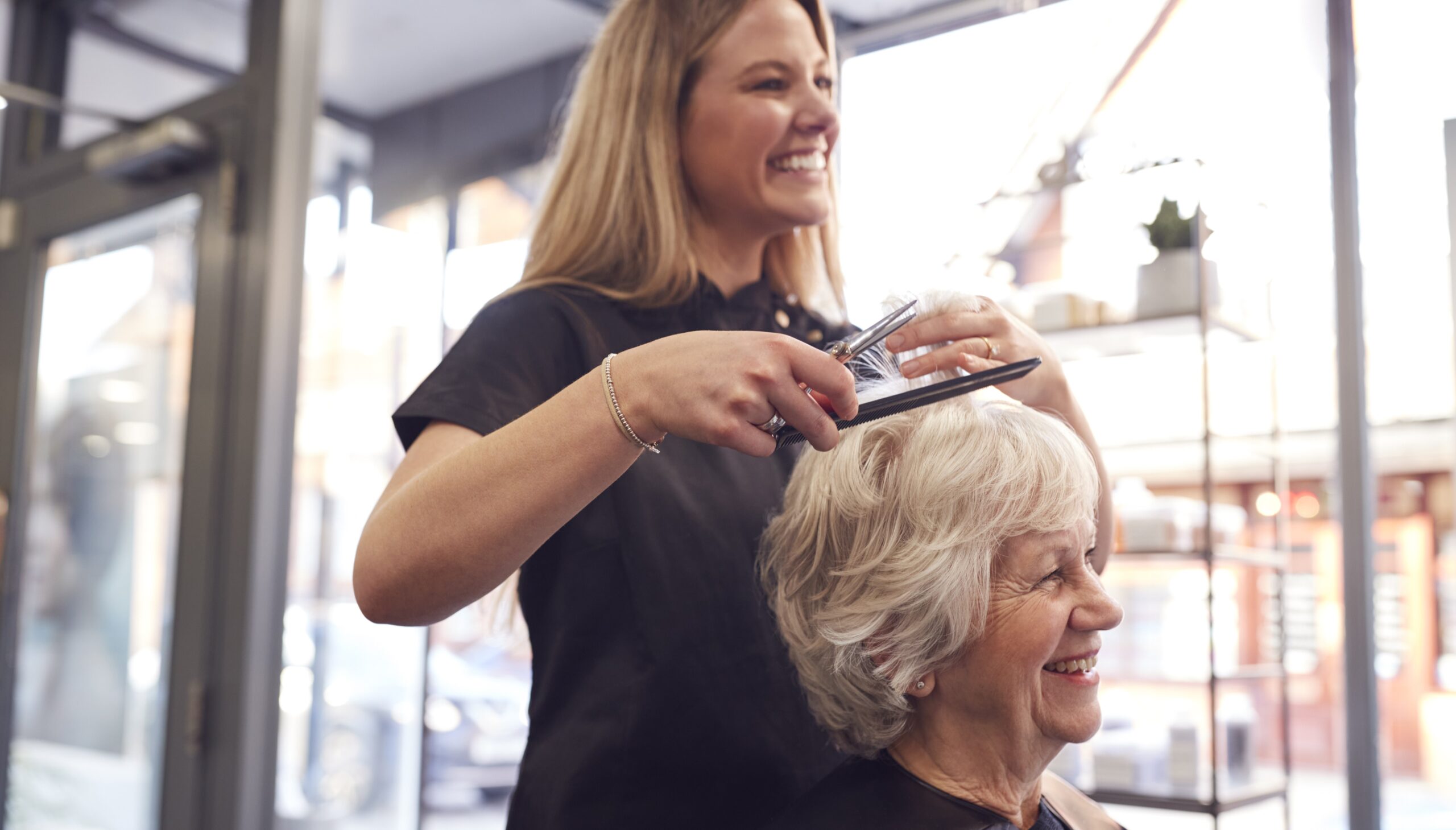 senior-woman-having-hair-cut-by-female-stylist-hairdressing-salon